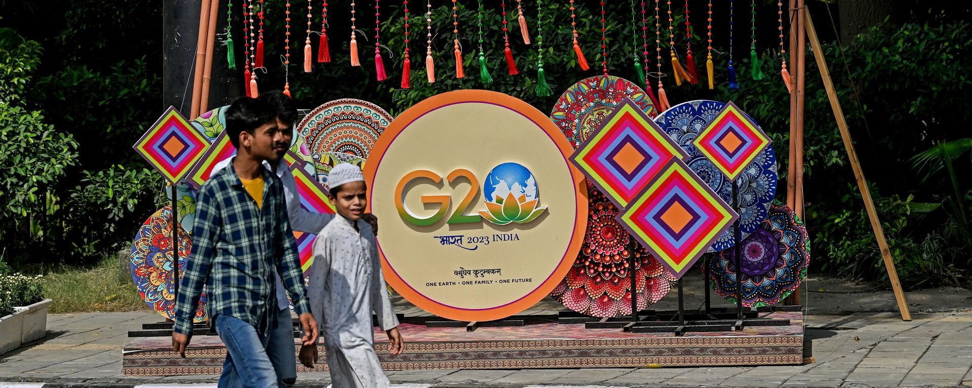 Pedestrians walk next to a G20 India summit logo ahead of its commencement in New Delhi on September 3, 2023. Pedestrians walk next to a G20 India summit logo ahead of its commencement in New Delhi on September 3, 2023. - Sputnik International, 1920, 09.09.2023