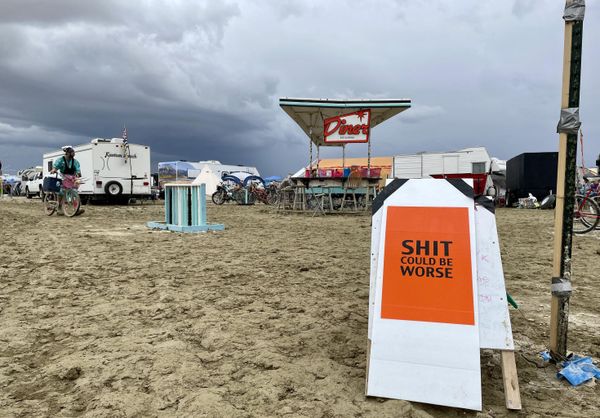 A sign reading "Sh*t Could Be Worse" as campers sit in the mud-covered site of the annual Burning Man festival in Nevada’s Black Rock desert on September 3, 2023. (Photo by Julie JAMMOT / AFP) - Sputnik International