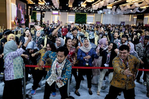 Journalists working at the media center start dancing and singing as the wall screen shows the live streaming of music performances during the gala dinner of the 43rd ASEAN Summit in Jakarta. - Sputnik International