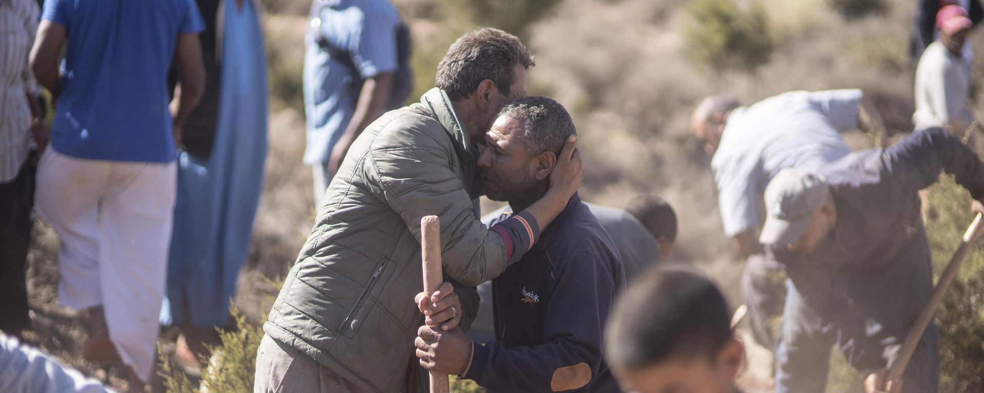 People comfort each other while digging graves for victims of the earthquake, in Ouargane village, near Marrakech, Morocco, Saturday, Sept. 9, 2023. A rare, powerful earthquake struck Morocco, sending people racing from their beds into the streets and toppling buildings in mountainous villages and ancient cities not built to withstand such force. People comfort each other while digging graves for victims of the earthquake, in Ouargane village, near Marrakech, Morocco, Saturday, Sept. 9, 2023. A rare, powerful earthquake struck Morocco, sending people racing from their beds into the streets and toppling buildings in mountainous villages and ancient cities not built to withstand such force. - Sputnik International, 1920, 09.09.2023