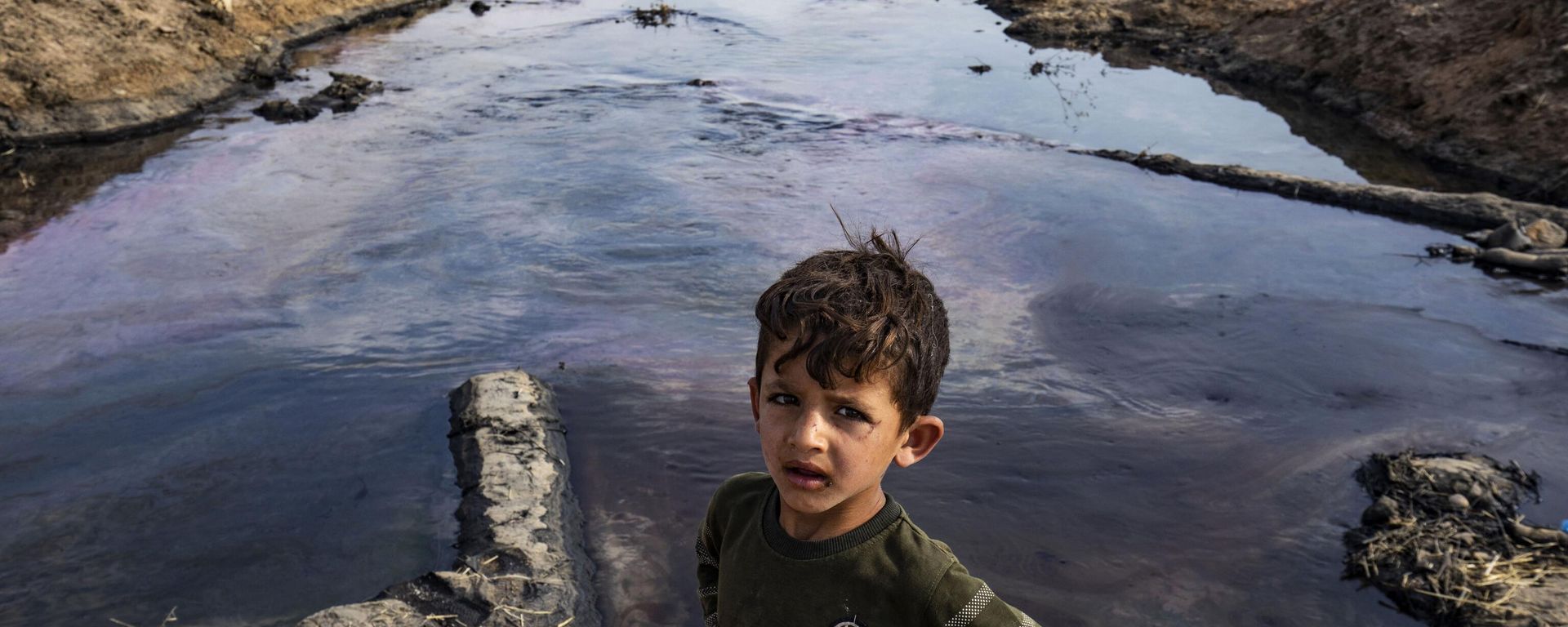 A child poses for a picture on the banks of a river polluted by a nearby oil field in the countryside of Rmeilan, in Syria's northeastern Hasakeh province on August 14, 2023. A child poses for a picture on the banks of a river polluted by a nearby oil field in the countryside of Rmeilan, in Syria's northeastern Hasakeh province on August 14, 2023. - Sputnik International, 1920, 11.09.2023