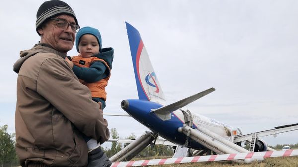Local residents pose for a photo near an Ural Airlines jetliner that made an emergency landing in a wheat field in Novosibirsk region, Russia. - Sputnik International