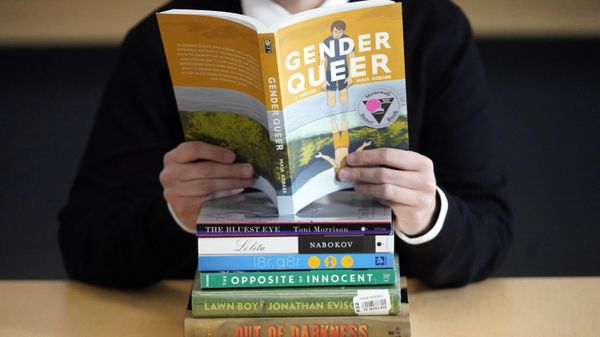 Amanda Darrow, director of youth, family and education programs at the Utah Pride Center, poses with books that have been the subject of complaints from parents on Dec. 16, 2021, in Salt Lake City. The nationwide surge in book bannings continues. The American Library Association reported Wednesday, Sept. 20, 2023, that challenges to books in schools and public libraries will likely reach record highs in 2023, topping what had been a record pace in 2022.  - Sputnik International