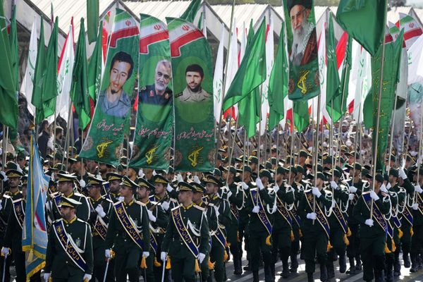 Iran's Revolutionary Guard members march as they carry flags with portraits of the Supreme Leader Ayatollah Ali Khamenei, right, and the late military commanders. - Sputnik International