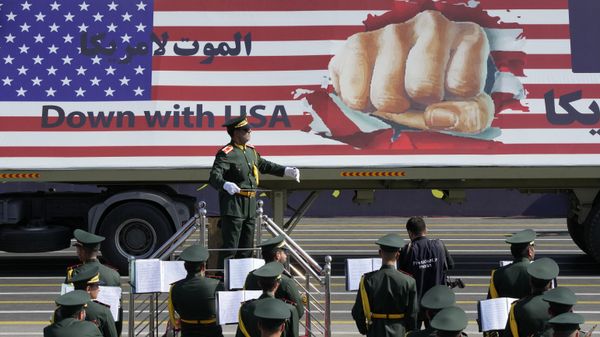 An anti-US banner is carried on a truck in an annual military parade marking anniversary of the beginning of war against Iran by Iraq - Sputnik International