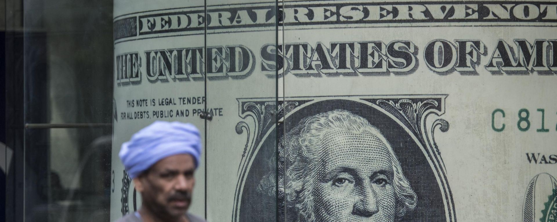 A man walks past a currency exchange shop displaying a giant US dollars banknote in downtown Cairo on November 3, 2016 A man walks past a currency exchange shop displaying a giant US dollars banknote in downtown Cairo on November 3, 2016 - Sputnik International, 1920, 24.09.2023
