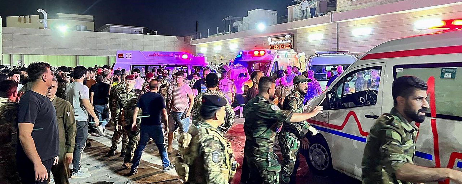 Soldiers and emergency responders gather around ambulances carrying wounded people after a fire broke out during a wedding at an event hall, outside the Hamdaniyah general hospital in Al-Hamdaniyah, Iraq on September 27, 2023. At least 100 people were killed and more than 150 injured when a fire broke out during a wedding at an event hall in the northern Iraqi town of Al-Hamdaniyah, according to state media and health officials, on September 27, 2023.  - Sputnik International, 1920, 27.09.2023