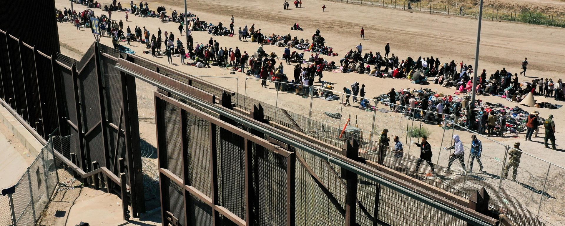 An aerial image shows migrants waiting along the border wall to surrender to US Customs and Border Protection (CBP) Border Patrol agents for immigration and asylum claim processing after crossing the Rio Grande river into the United Staes on the US-Mexico border in El Paso, Texas, on May 10, 2023. An aerial image shows migrants waiting along the border wall to surrender to US Customs and Border Protection (CBP) Border Patrol agents for immigration and asylum claim processing after crossing the Rio Grande river into the United Staes on the US-Mexico border in El Paso, Texas, on May 10, 2023. - Sputnik International, 1920, 05.10.2023