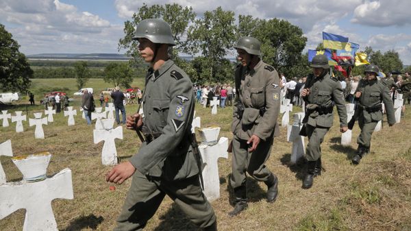 Ukrainians dressed in the SS Galychyna Division uniform march past graves during a re-burial ceremony on the SS Galychyna Division cemetery near the village of Chervone in western Ukraine on Sunday, July 21, 2013. - Sputnik International