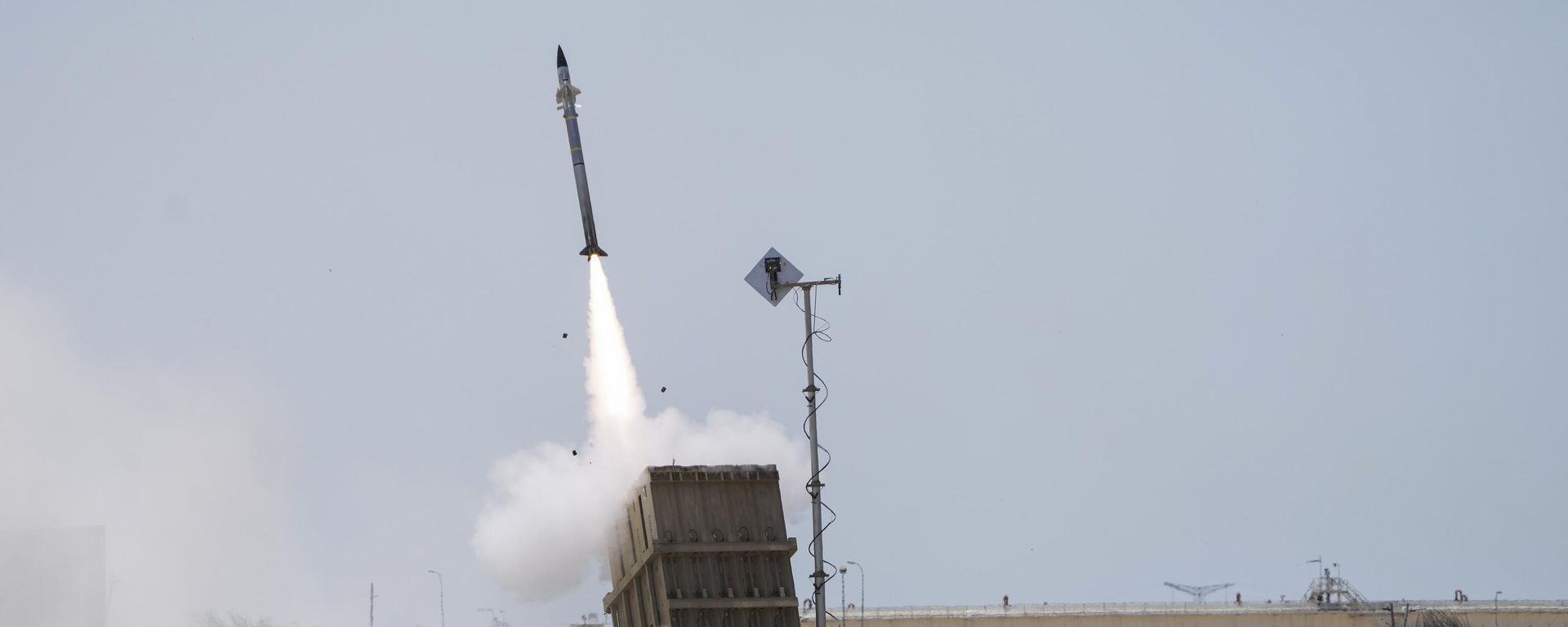 An Israeli soldier takes cover as an Iron Dome air defence system launches to intercept a rocket fired from the Gaza Strip, in Ashkelon, southern Israel, Sunday, Aug. 7, 2022.  - Sputnik International, 1920, 09.10.2023