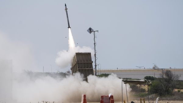 An Israeli soldier takes cover as an Iron Dome air defence system launches to intercept a rocket fired from the Gaza Strip, in Ashkelon, southern Israel - Sputnik International