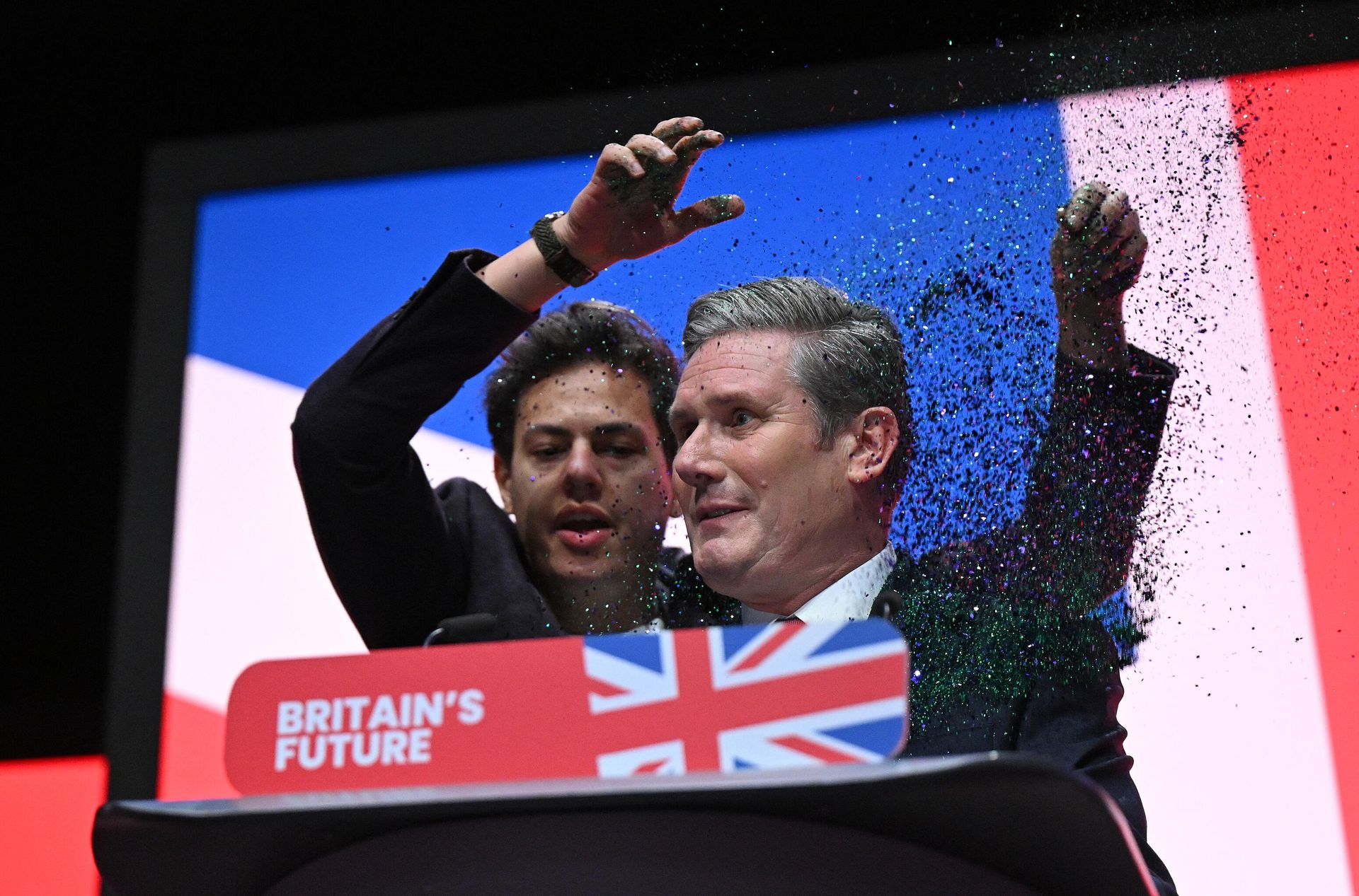 A protester throws glitter on Britain's main opposition Labour Party leader Keir Starmer (R) at the start of his keynote address to delegates on the third day of the annual Labour Party conference in Liverpool, northwest England, on October 10, 2023. A protester throws glitter on Britain's main opposition Labour Party leader Keir Starmer (R) at the start of his keynote address to delegates on the third day of the annual Labour Party conference in Liverpool, northwest England, on October 10, 2023. - Sputnik International, 1920, 10.10.2023