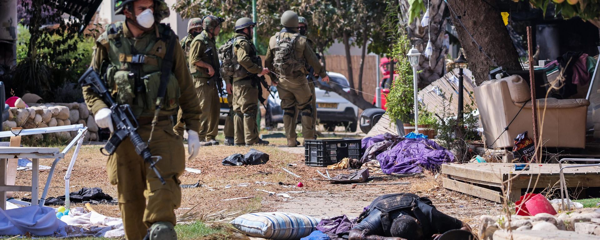 Israeli soldiers stand near the body of a Palestinian militant in Kfar Aza, in the south of Israel, bordering Gaza Strip on October 10, 2023.  - Sputnik International, 1920, 11.10.2023