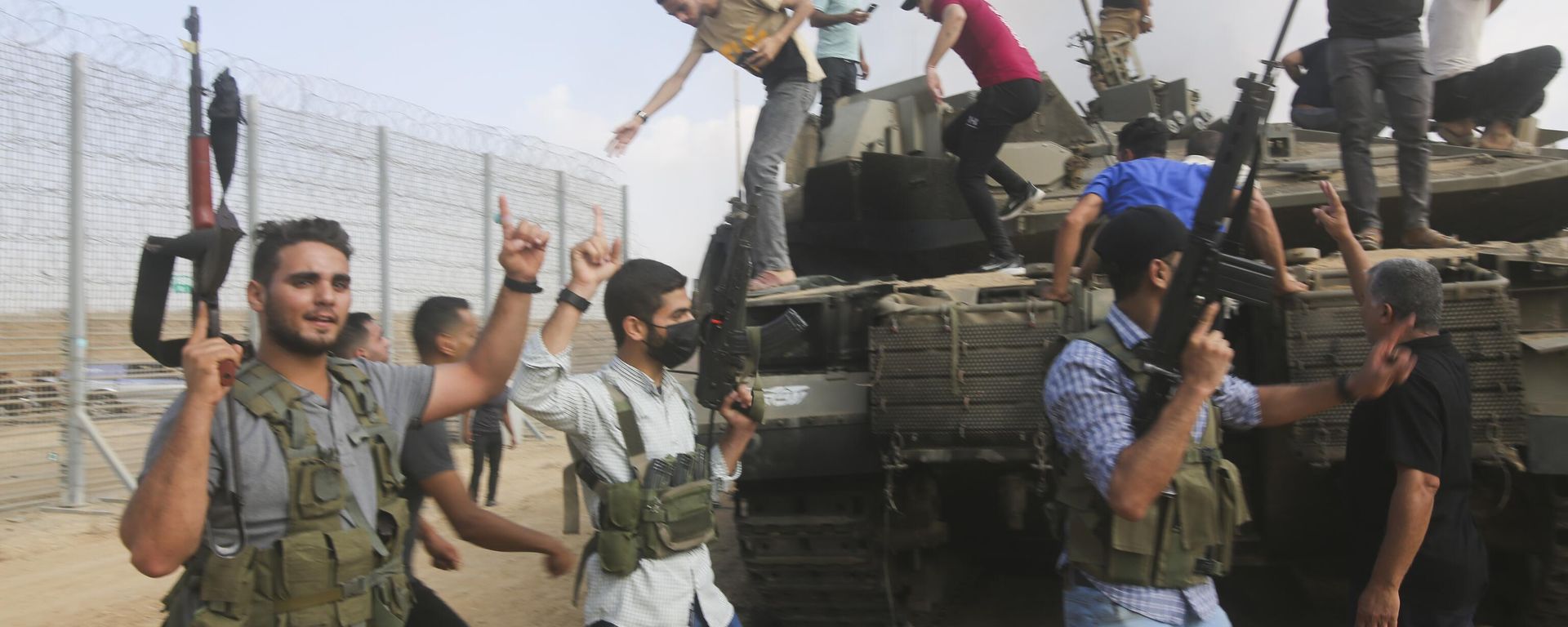 Palestinian militants celebrate by an Israeli tank at the border fence of the Gaza Strip Palestinian militants celebrate by an Israeli tank at the border fence of the Gaza Strip - Sputnik International, 1920, 25.10.2023