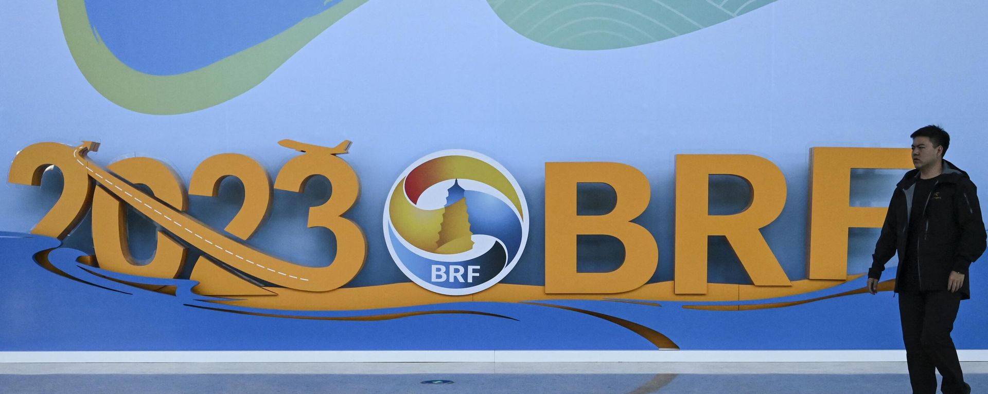 A man walks past the logo of the Belt and Road Forum at the National Convention Center in Beijing on October 15, 2023. A man walks past the logo of the Belt and Road Forum at the National Convention Center in Beijing on October 15, 2023. - Sputnik International, 1920, 17.10.2023