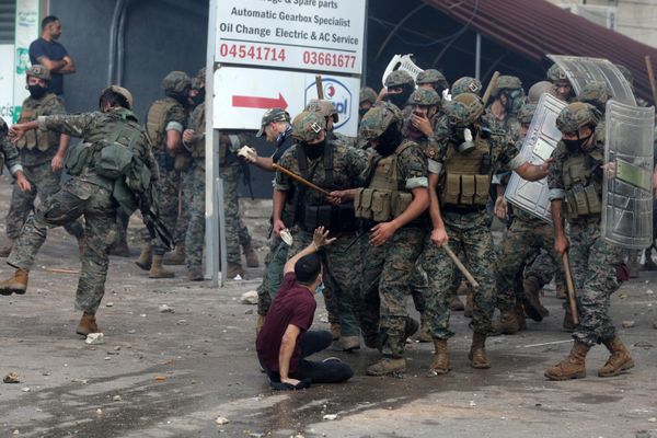 Lebanese security forces threaten a young man with batons as they clash with protesters outside the US Embassy in Awkar east of Beirut, during a demonstration in solidarity with the Palestinians of the Gaza Strip. - Sputnik International