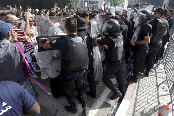 Riot police stand guard as thousands of protesters gather outside the French embassy in Tunis, Tunisia. - Sputnik International