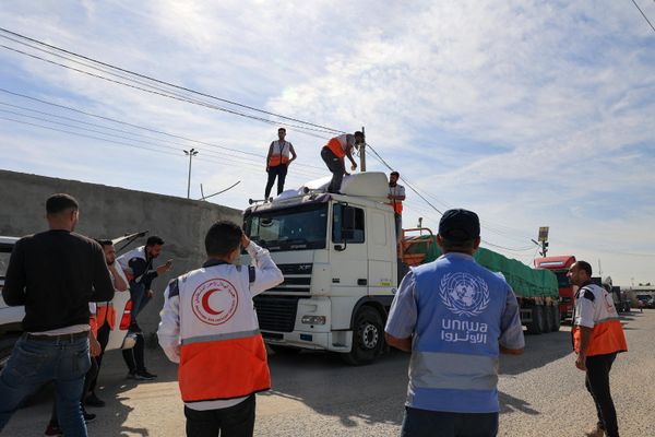 Aid workers gather around trucks delivering humanitarian aid that entered the Gaza Strip from Egypt via the Rafah border crossing on 21 October 2023.  - Sputnik International