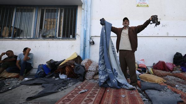 Palestinians react to the debris after an Israeli strike near an United Nations Relief and Works Agency for Palestine Refugees (UNRWA) school in Khan Yunis, in the southern Gaza Strip on October 21, 2023. - Sputnik International