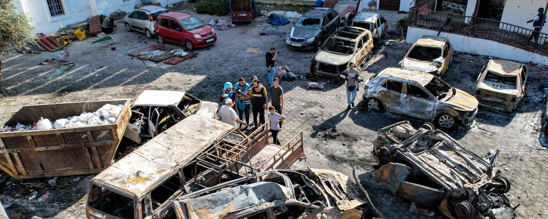 This aerial view shows people standing before destroyed buildings at the site of the Ahli Arab hospital in central Gaza on October 18, 2023 in the aftermath of an overnight strike there, which killed hundreds of people late on October 17, sparking global condemnation and angry protests around the Muslim world. This aerial view shows people standing before destroyed buildings at the site of the Ahli Arab hospital in central Gaza on October 18, 2023 in the aftermath of an overnight strike there, which killed hundreds of people late on October 17, sparking global condemnation and angry protests around the Muslim world. - Sputnik International, 1920, 28.10.2023