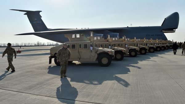 Ukrainian servicemen walk in front of US armoured cars at Kiev airport. File photo - Sputnik International