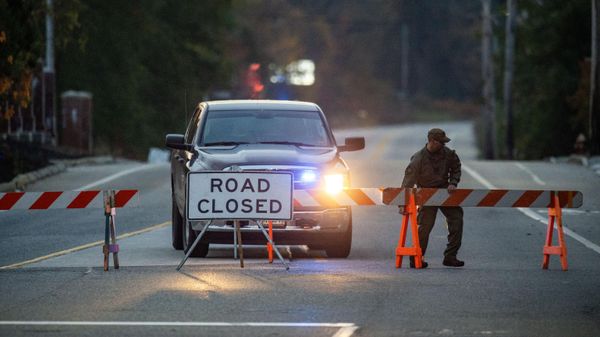 A law enforcement official moves a road block into place blocking the road to Schemengees Bar where a shooting took place yesterday in Lewiston, Maine on October 26, 2023.  - Sputnik International