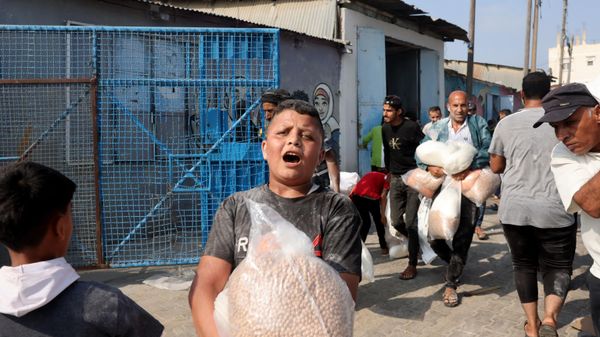 A Palestinian boy holds a bag of chickpeas received at the UN humanitarian center in Deir el-Balah. - Sputnik International