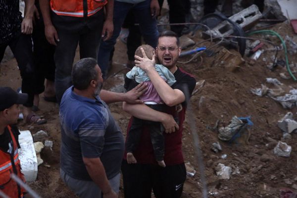 A distraught Palestinian man holding a dead child who was found under the rubble of a demolished building following Israeli airstrikes on the Nusseirat refugee camp, in the central Gaza Strip.  - Sputnik International