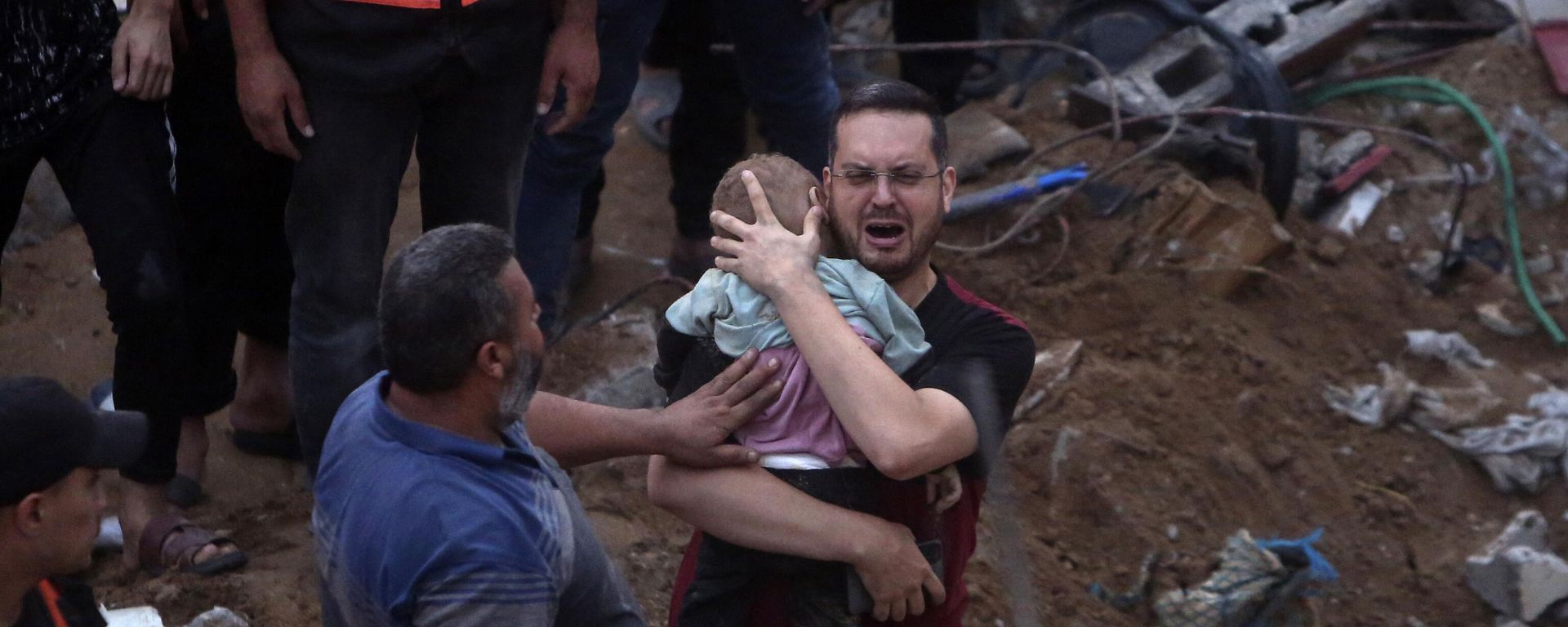 A Palestinian man cries while holding a dead child who was found under the rubble of a destroyed building following Israeli airstrikes in Nusseirat refugee camp, central Gaza Strip, Tuesday, Oct. 31, 2023 - Sputnik International, 1920, 10.07.2025