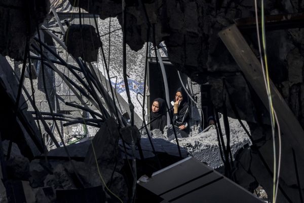 Two women peer out of a destroyed building's window in Rafah, located in the southern Gaza Strip, looking at the destructive aftermath of Israel's heavy bombardment. - Sputnik International