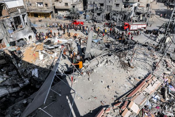 Crowds stand waiting as civil defense workers tirelessly search for victims and survivors in the rubble of a building struck by Israel's bombardment in Rafah, located in the southern Gaza Strip. - Sputnik International