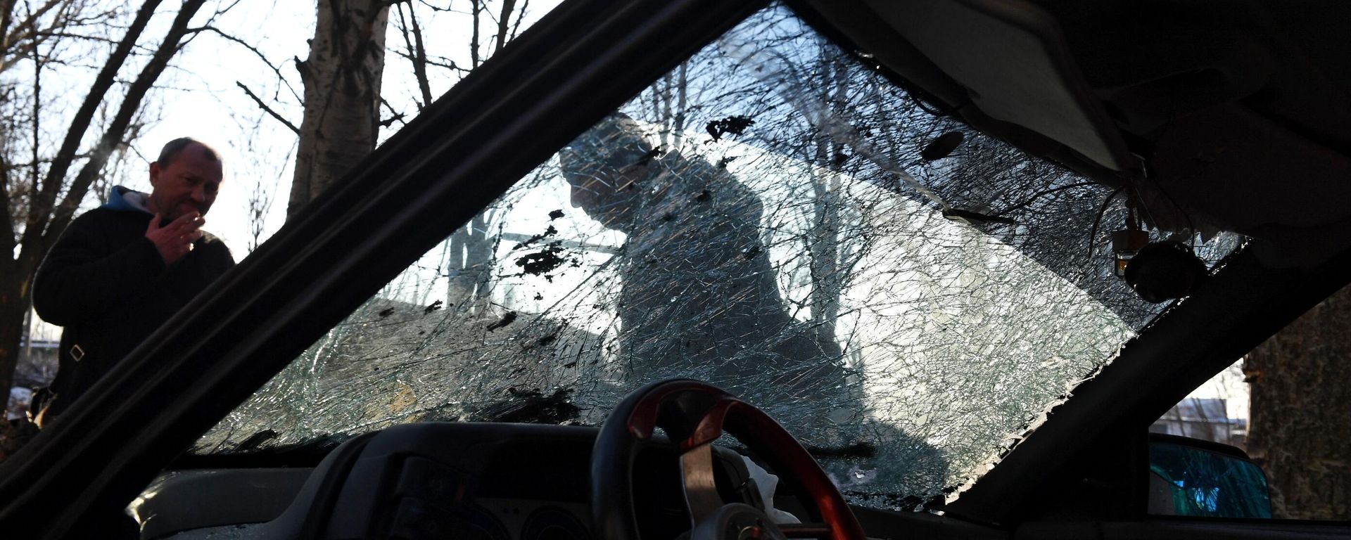 Men look at a car damaged by shelling in the course of Russia's military operation in Ukraine, in Donetsk, the Donetsk People's Republic, Russia. - Sputnik International, 1920, 04.11.2023