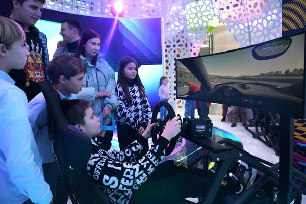 Young visitor of the RUSSIA EXPO is trying a driving simulator - Sputnik International