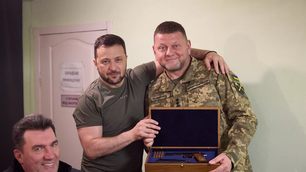 Ukrainian President Volodymyr Zelensky presents Armed Forces Commander-in-Chief Valerii Zaluzhnyi with a customized firearm. File photo. - Sputnik International