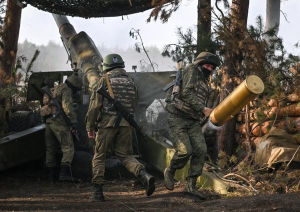 Soldier rushes to carry an empty shell casing of a 2A36 field gun as it is reloaded. - Sputnik International