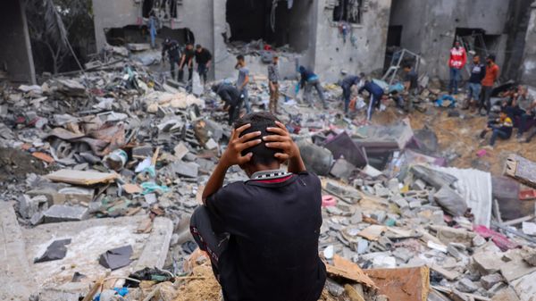 A child reacts as people salvage belongings amid the rubble of a damaged building following strikes on Rafah in the southern Gaza Strip. - Sputnik International