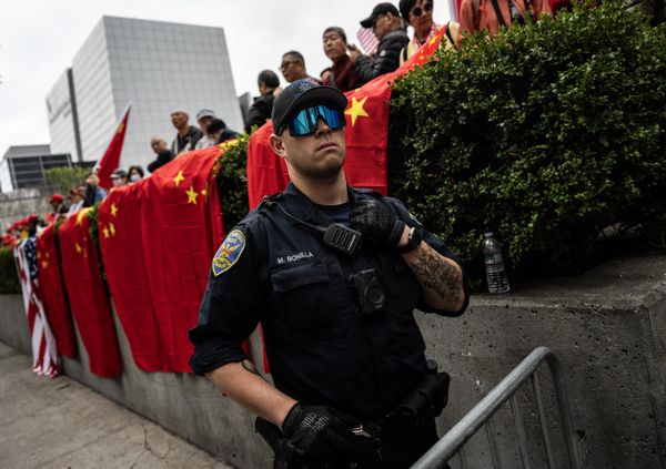 A police office looks on happily as supporters await the arrival of China's President Xi Jinping next to the Asia-Pacific Economic Cooperation summit headquarters in San Francisco. - Sputnik International