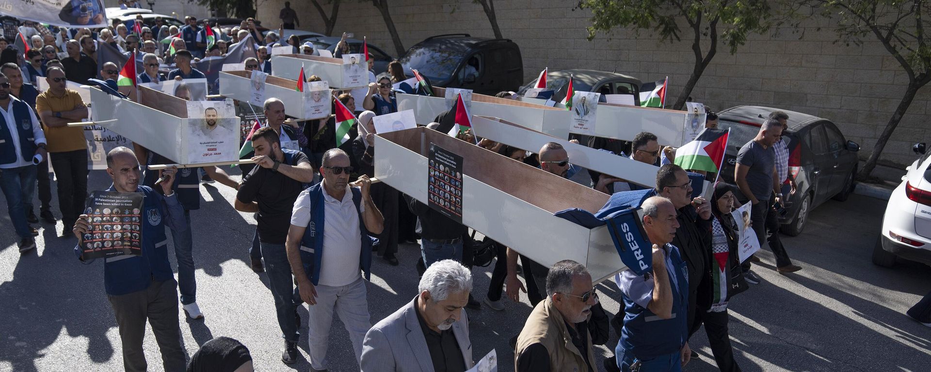 Palestinian journalists carry mock coffins of Palestinian journalists who were killed during the current war in Gaza during a symbolic funeral toward a United Nations office, in the West Bank city of Ramallah - Sputnik International, 1920, 17.11.2023