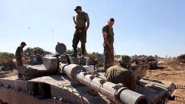 Israeli soldiers stand on their tank positioned close to the Israel's border with the Gaza Strip, in southern Israel on November 16, 2023. - Sputnik International