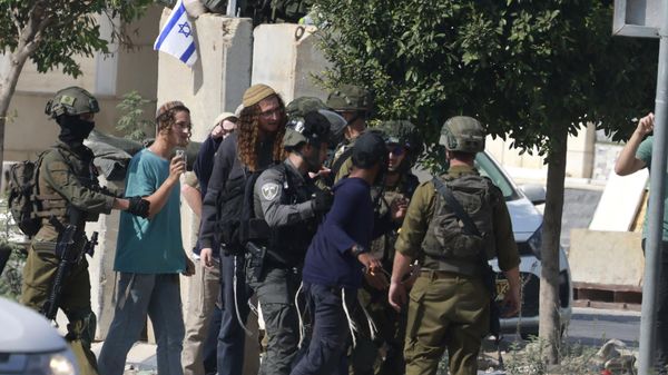 Israeli soldiers restrain Jewish settlers after they stormed the Palestinian West Bank village of Dayr Sharaf, located about seven kilometres (four miles) from the Jewish Einav settlement following the death of an Israeli man on November 2, 2023, amid the ongoing battles between Israel and the Palestinian group Hamas in the Gaza Strip - Sputnik International