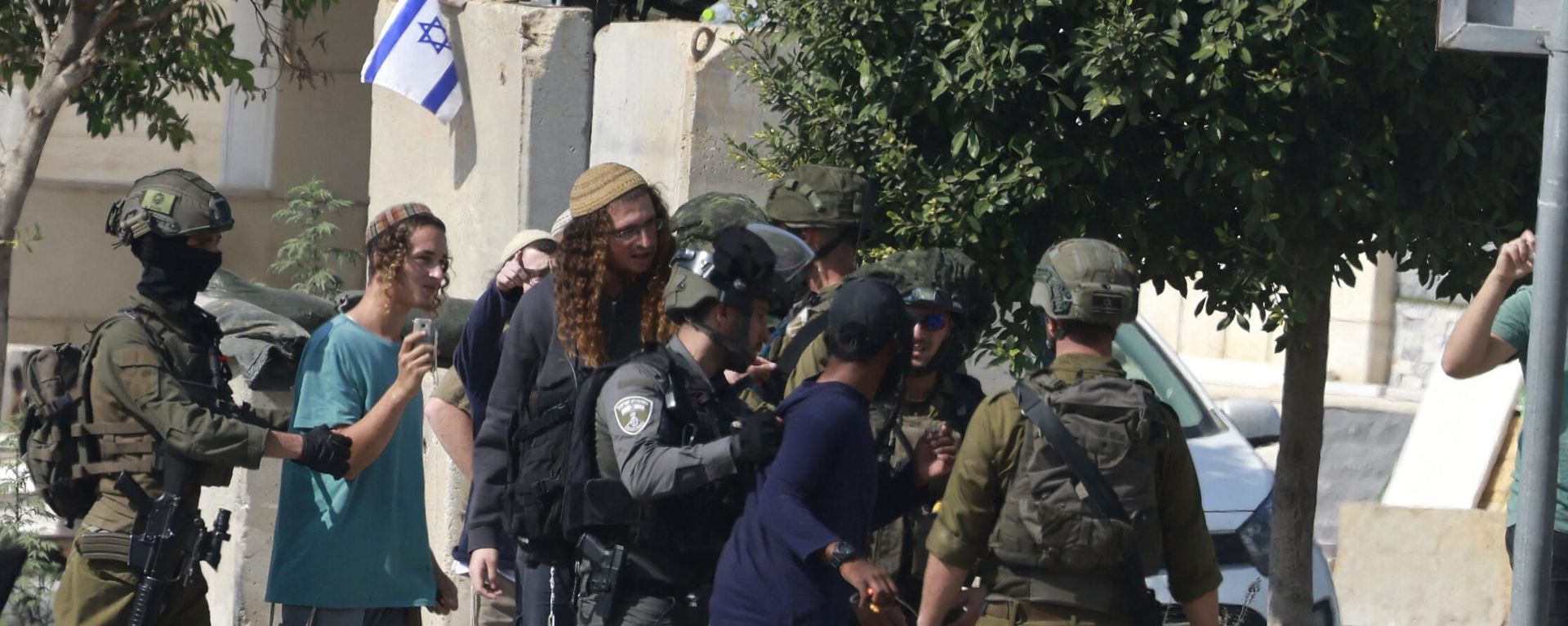 Israeli soldiers restrain Jewish settlers after they stormed the Palestinian West Bank village of Dayr Sharaf, located about seven kilometres (four miles) from the Jewish Einav settlement following the death of an Israeli man on November 2, 2023, amid the ongoing battles between Israel and the Palestinian group Hamas in the Gaza Strip - Sputnik International, 1920, 21.11.2023