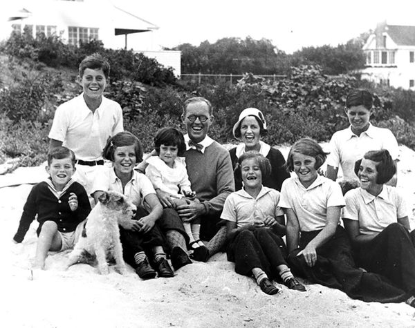 The Kennedy family at Hyannis Port, 1931. L-R: Robert Kennedy, John F. Kennedy, Eunice Kennedy, Jean Kennedy (on lap of) Joseph P. Kennedy Sr., Rose Fitzgerald Kennedy (behind) Patricia Kennedy, Kathleen Kennedy, Joseph P. Kennedy Jr. (behind) Rosemary Kennedy. The dog in foreground is "Buddy." Photograph by Richard Sears in the John F. Kennedy Presidential Library and Museum, Boston. - Sputnik International