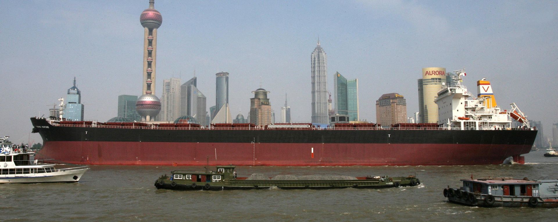 A large cargo vessel makes it's way down the Huangpu River in front of the Pudong financial district in Shanghai A large cargo vessel makes it's way down the Huangpu River in front of the Pudong financial district in Shanghai - Sputnik International, 1920, 22.11.2023