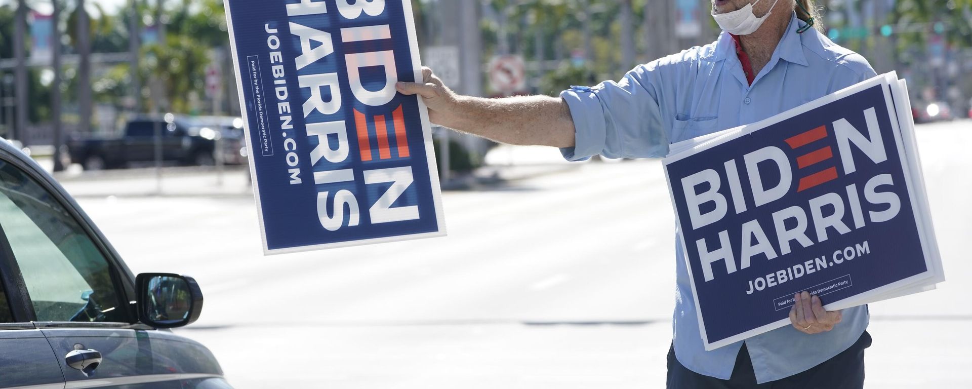 Bob Remmen gives out Biden Harris signs next to a site where people gathered to watch the inauguration of President Joe Biden on a mobile screen, Wednesday, Jan. 20, 2021, outside the famed Freedom Tower in downtown Miami. Bob Remmen gives out Biden Harris signs next to a site where people gathered to watch the inauguration of President Joe Biden on a mobile screen, Wednesday, Jan. 20, 2021, outside the famed Freedom Tower in downtown Miami. - Sputnik International, 1920, 27.11.2023