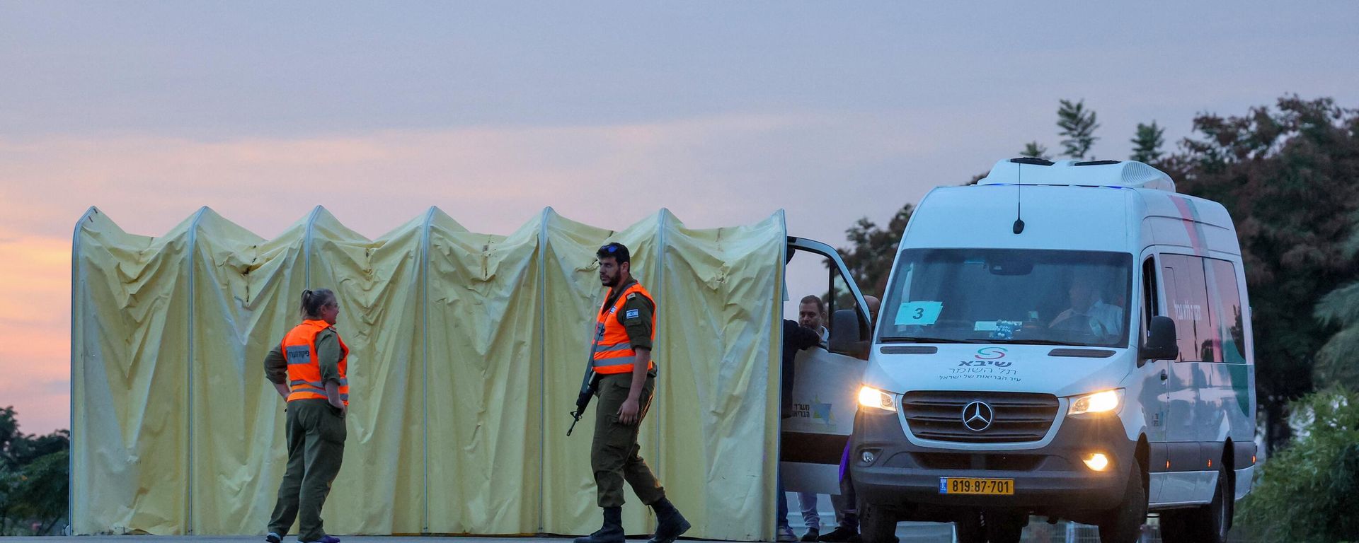 Members of Israel's security forces stand next to an ambulance as medical staff prepare for the arrival of Israeli hostages to be released by Hamas from the Gaza Strip outside Ramat Gan's Sheba medical centre in the Tel Aviv district on November 25, 2023 - Sputnik International, 1920, 29.11.2023