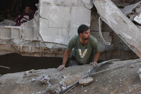 A Palestinian man looks for survivors amid the destruction in a residential building following Israeli air strikes in the Rafah refugee camp in the southern Gaza Strip, December 1, 2023. - Sputnik International