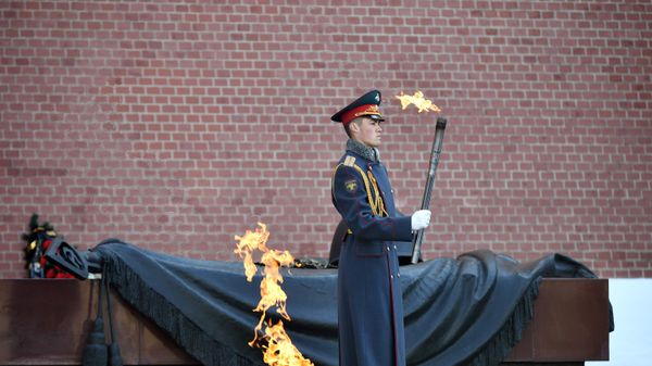 A serviceman of the Honor Guard holds a torch with the Eternal Flame near the Tomb of the Unknown Soldier. - Sputnik International