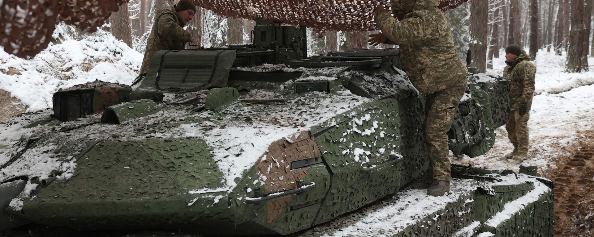 Ukrainian tank crew members of the 21st Mechanized Brigade stands on a snow covered German made Leopard 2A5 battle tank near the front line in an undisclosed location in the Lyman direction of the Donetsk region, on November 21, 2023 Ukrainian tank crew members of the 21st Mechanized Brigade stands on a snow covered German made Leopard 2A5 battle tank near the front line in an undisclosed location in the Lyman direction of the Donetsk region, on November 21, 2023 - Sputnik International, 1920, 14.12.2023