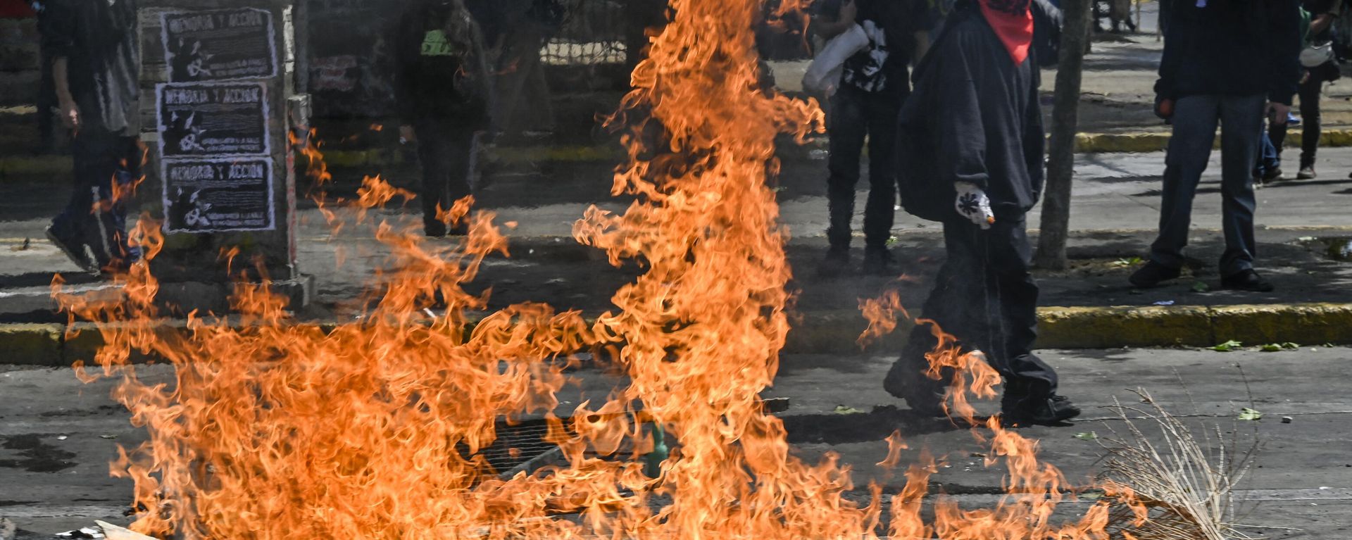 Demonstrators block a street with a barricade set on fire during a protest to commemorate the third anniversary of a social uprising against rising utility prices, in the surroundings of the Baquedano square in Santiago, on October 18, 2022 Demonstrators block a street with a barricade set on fire during a protest to commemorate the third anniversary of a social uprising against rising utility prices, in the surroundings of the Baquedano square in Santiago, on October 18, 2022 - Sputnik International, 1920, 08.12.2023