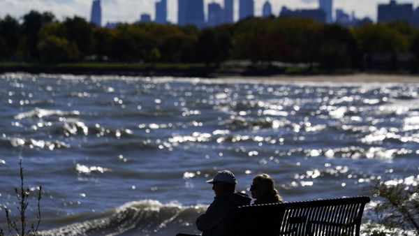 A couple sits on the bench on the shore of Lake Michigan as the downtown skyline is seen in the background, Sunday, Oct. 22, 2023, in Chicago. - Sputnik International
